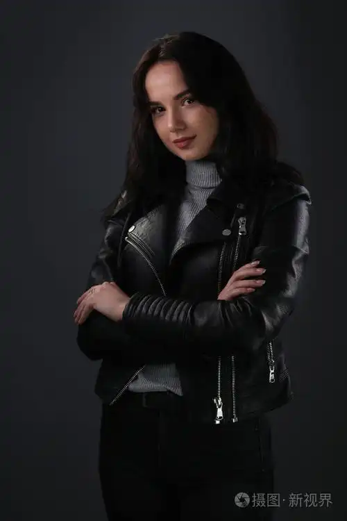 黑色皮革夹克的女孩在深灰色背景