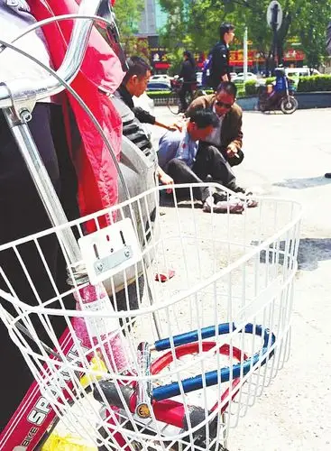 面对围观市民的指点,张某低头不语.