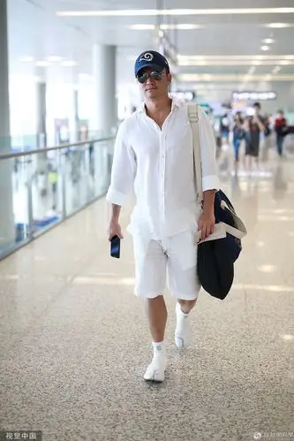 黑白配?吴京肤色"黑"引热议 一身白衣现身机场