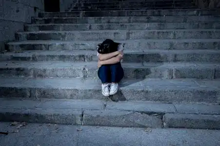 孤独忧伤美丽而忧伤的拉美裔女人,绝望和沮丧的坐在城市街道楼梯上