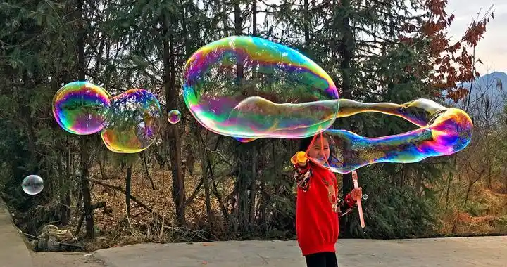 小女孩活泼好动,玩起的七彩泡泡里,充满着各种浪漫美好的幻想