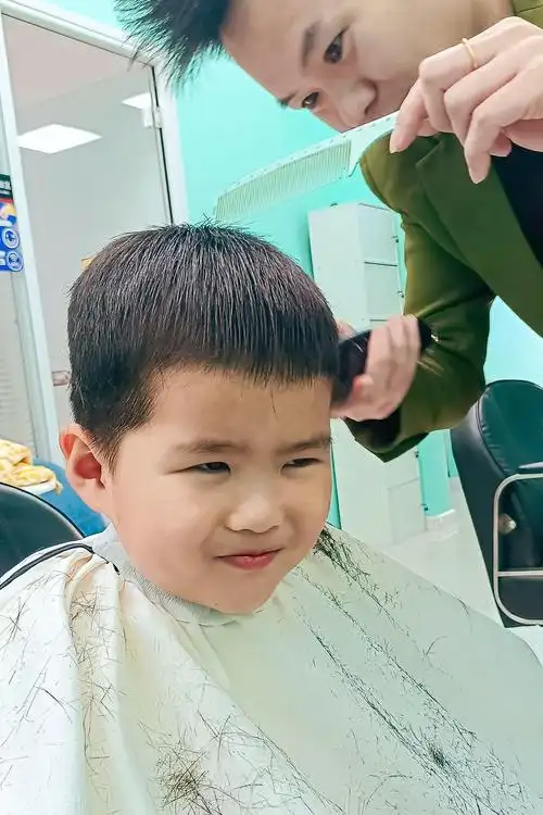 3月11日,在青岛市李沧区浮山路街道,小朋友在一家理发店理发.张鹰 摄