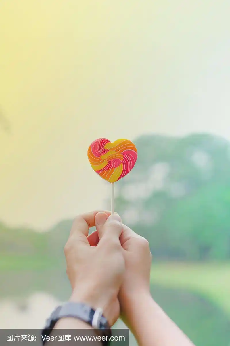 手握棒棒糖在模糊的背景