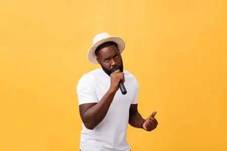 的非洲裔美国人男孩唱歌情感与麦克风查出的黄色背景, 在运动手势照片