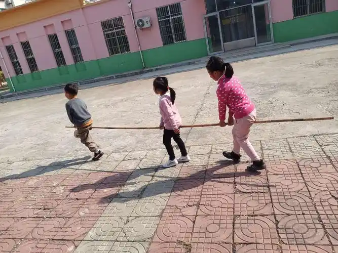 幼儿按照自己的队伍站成两竖队,并将两腿分开,跨在竹竿上,双手握住
