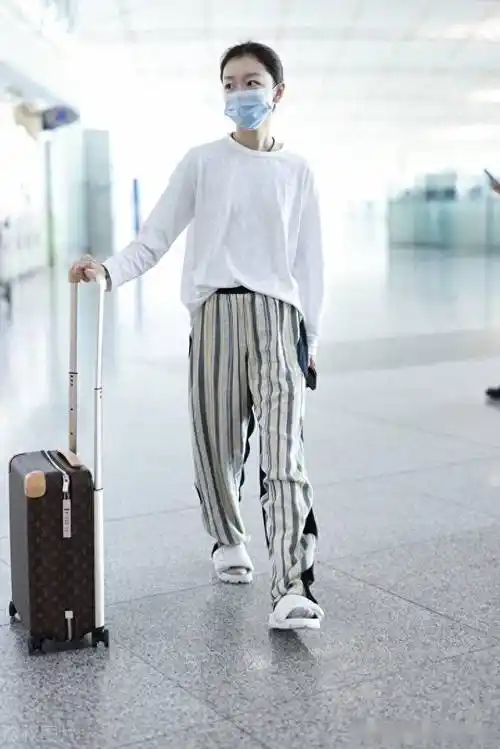 街拍:周冬雨白色t恤 条纹长裤 拖鞋休闲随性_北京_机场