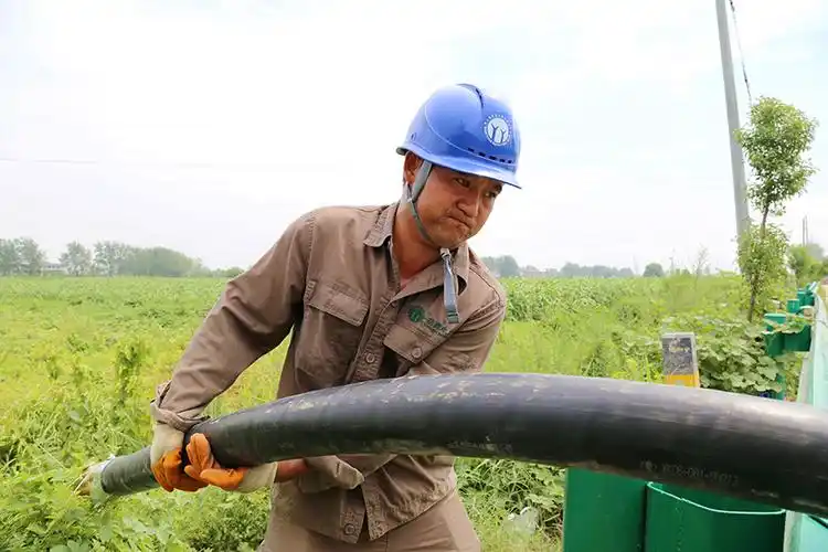 施工人员在高温下奋力敷设高压电缆.刘喆摄