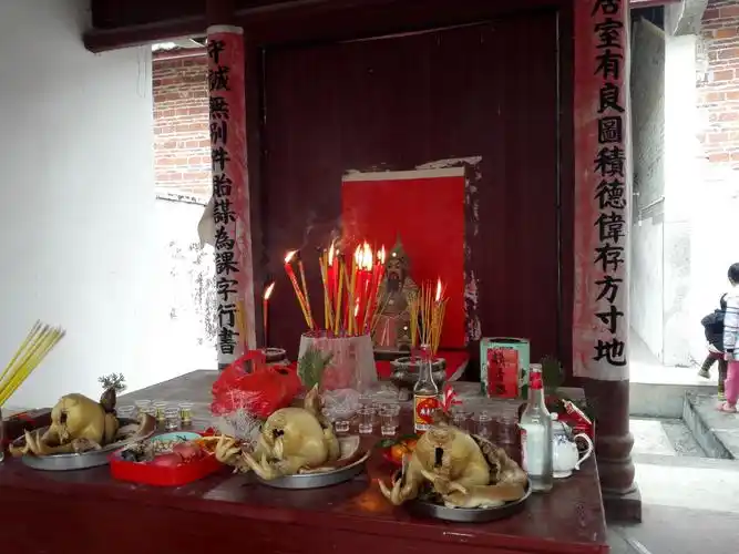 鸡,水果,糖果,饼干,茶,酒等祭品在供桌上摆得满满.