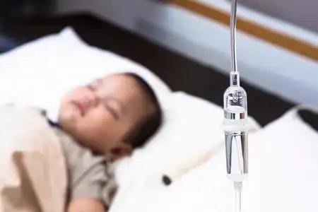 与脉搏血氧仪传感器和外周静脉留置针在儿童医院婴儿在病床上静脉输液