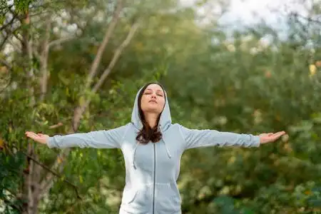 在公园里做深呼吸练习的美女照片
