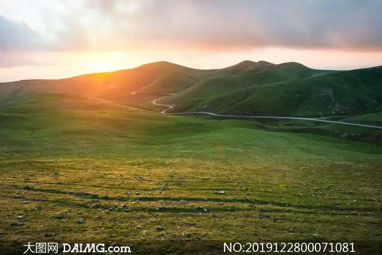 夕阳下的草原和山丘高清摄影图片