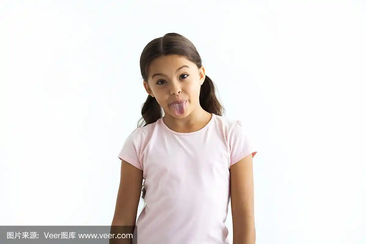 在白色墙壁的背景上,快乐的女孩伸出舌头