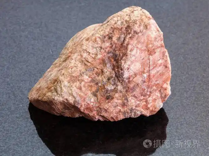 原始的粉红色花岗岩石头在黑暗的背景