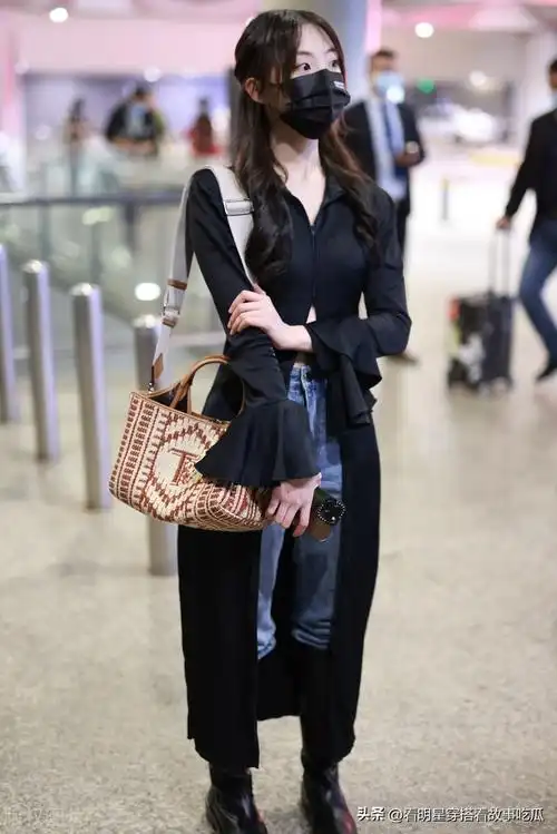 郑乃馨现身虹桥机场身着露脐黑色开叉连衣裙搭配牛仔裤美丽动人