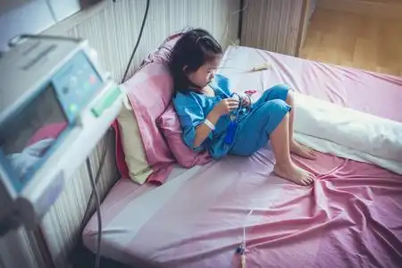 患病亚洲儿童手上有生理盐水输液照片