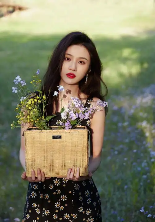 照片中,张慧雯身缠黑色碎花长裙,手捧一筐野花,温柔纯真.1/9