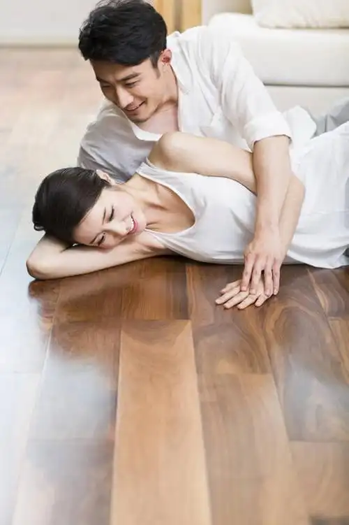 快乐的年轻情侣躺在木地板上