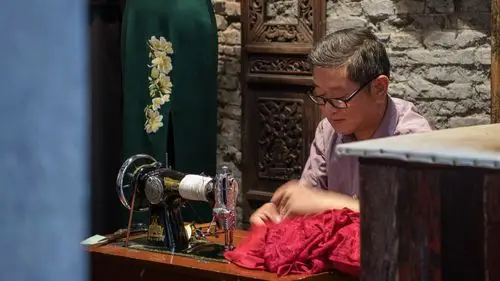 弄堂内裁缝店老裁缝在仔细改衣服