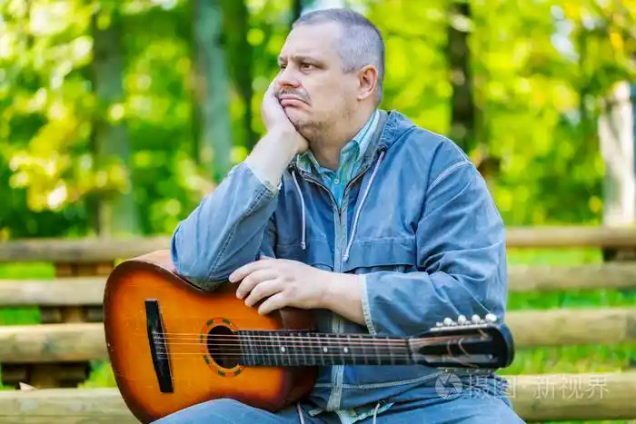 在公园长椅上弹吉他伤心人