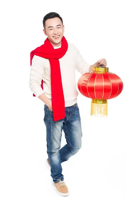 年轻男子手持中国红灯笼庆祝新年图片下载