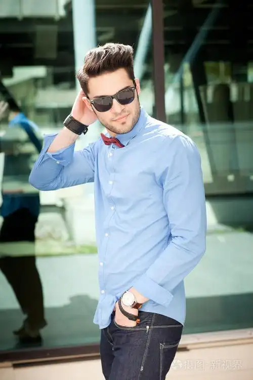 有吸引力的年轻男性模型户外摆了蓝色衬衫和太阳镜