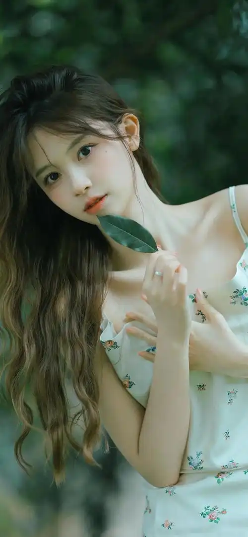 穿着碎花吊带裙女孩拿着一张树叶锁骨很漂亮手机壁纸