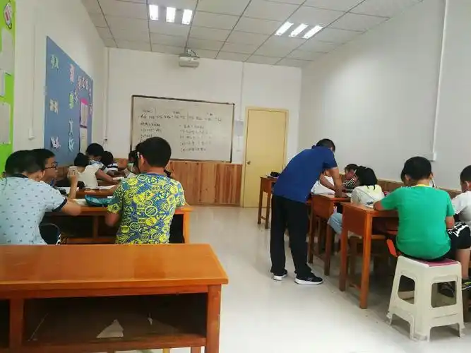 老师认真辅导学生做课堂练习,巩固上课所学习的知识.