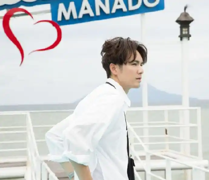 钟汉良白衬衣搭配休闲牛仔棕发轻扬诠释海边旅行客