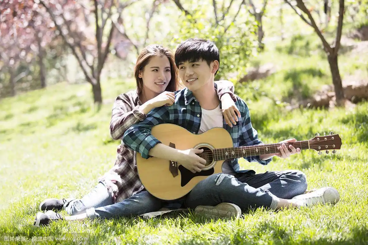 浪漫情侣草地上弹吉他