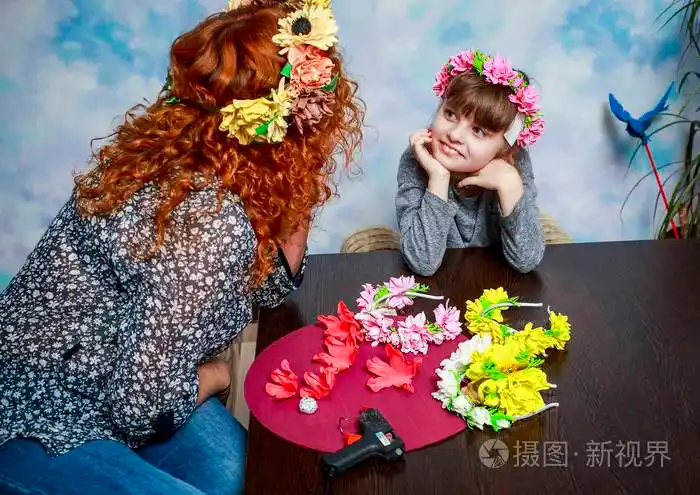 妈妈和女儿在人造花的头上做美丽的花圈照片-正版商用图片06muhb-摄图