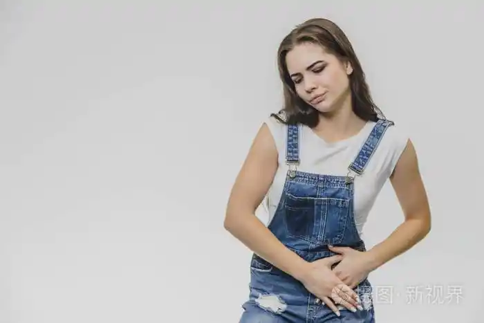捂着肚子感受着痛苦的情绪她辛苦工作后感到疼痛一件漂亮的白色t恤