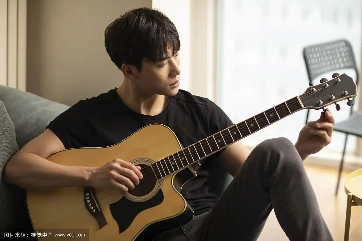 年轻男士在家弹吉他