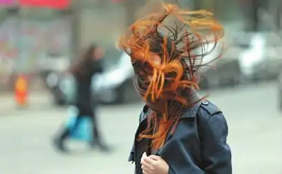 昨天的天气让长春的美女们很没面子,一名出行的女子头发被吹乱 新文化