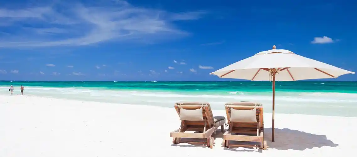蓝天白云沙滩太阳伞下两个椅子海边休闲度假假期