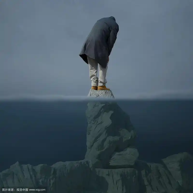 站在海中突出岩石上的无助的人