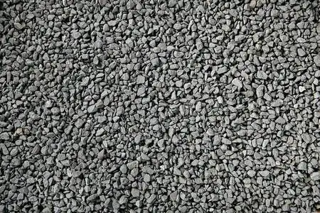 岩石铺路自然的灰色花岗岩碎屑,铺路用的碎石料,碎石或压碎的石头照片