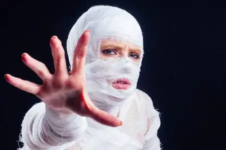 迷人的木乃伊女人全身缠着绷带,黑色背景照片