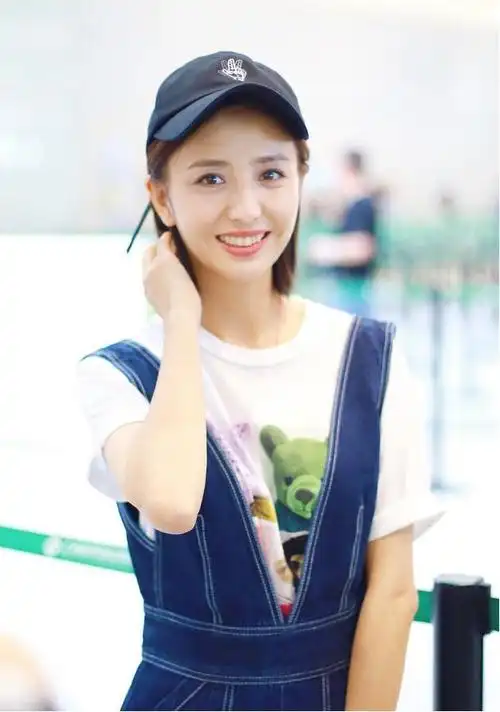 佟丽娅笑容迷人,穿背带裤开叉到胃,搭件玩具熊t恤有反差萌