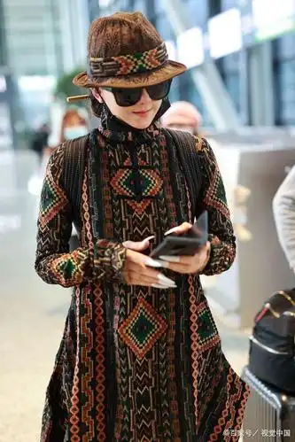 62岁杨丽萍对镜举手长甲超吸睛,穿民族花纹连衣裙配同色帽超飒