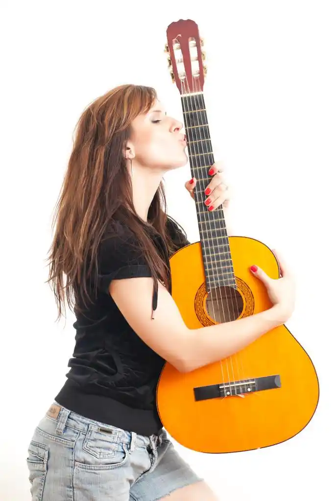 拿着吉他的女人,美丽的年轻女子抱着吉他在白色背景上