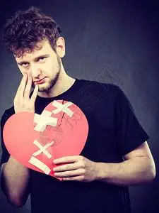 心碎的概念悲伤男人拿着爱标志人类感觉被石膏所恢复情人节悲伤的被