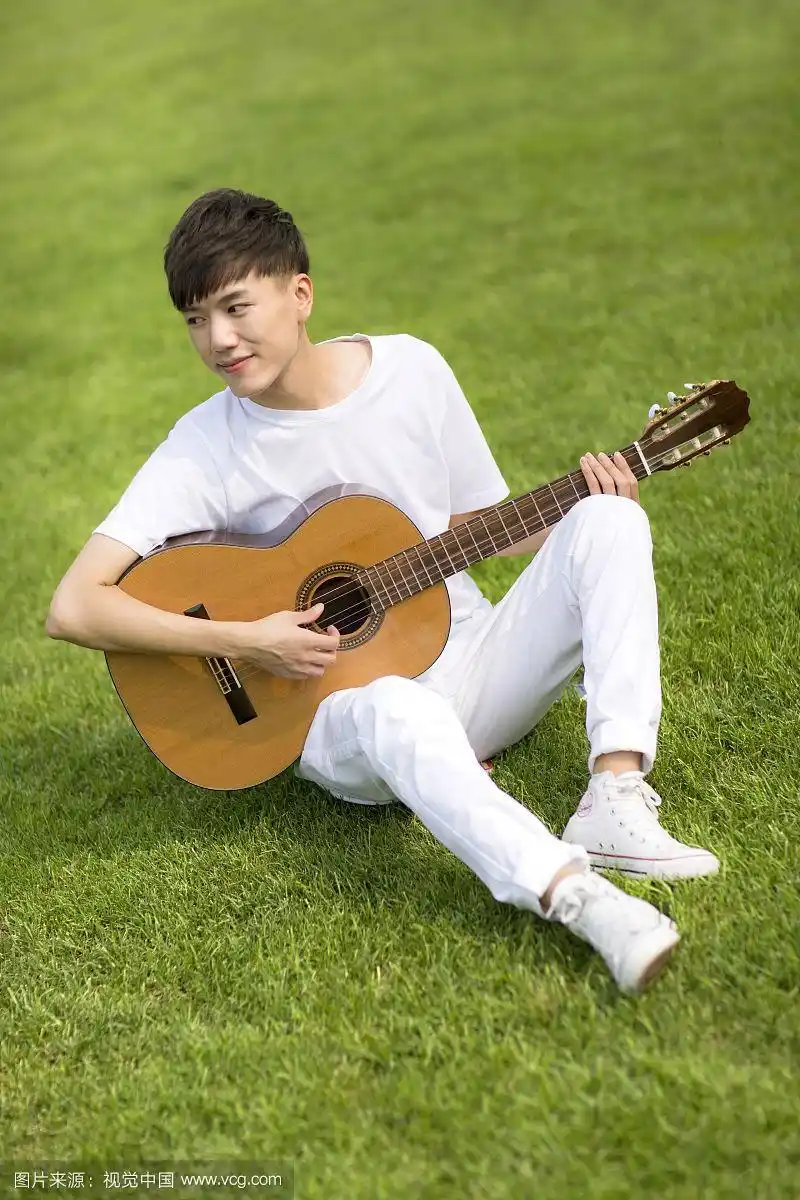 坐着弹吉他的男学生