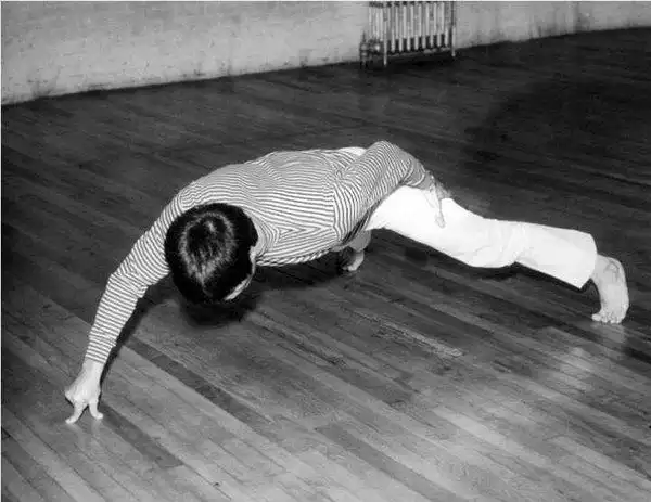 一代功夫巨星李小龙旧照用二指禅做俯卧撑图