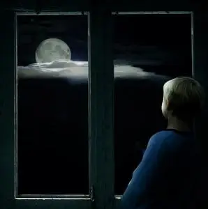 窗外月亮男孩在黑暗的窗外,望着皎洁的月亮照片