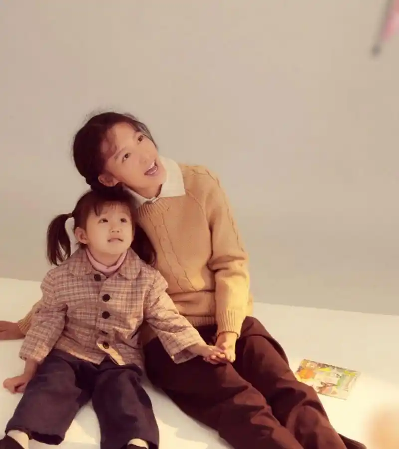 李沁和剧中的女儿合影,抱着孩子一脸和善笑容,一看就是好性格的姑娘