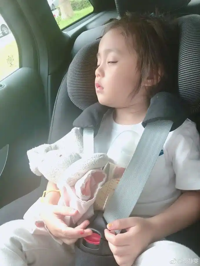 这张照片,咘咘可能是玩累了,躺在车上睡觉,眼睛还微张着,画风有些好笑