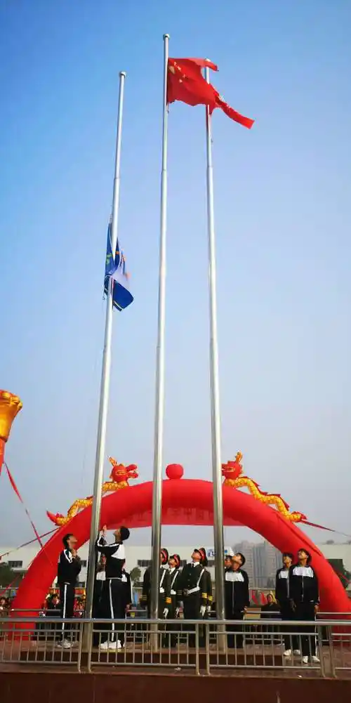 三面旗帜冉冉升起,在会场上空随风飘荡,庄严肃穆.