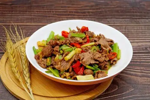 木桌背景中的一盘芹菜炒牛肉小炒黄牛肉