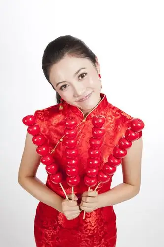 棚拍节日身穿红色旗袍的年轻女人拿着糖葫芦|优图佳视