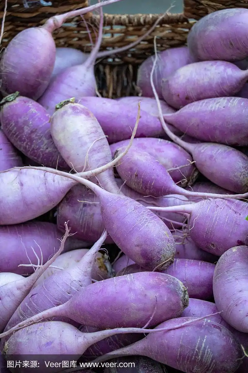 美丽的紫色萝卜在一个棕色的柳条篮子里的特写.